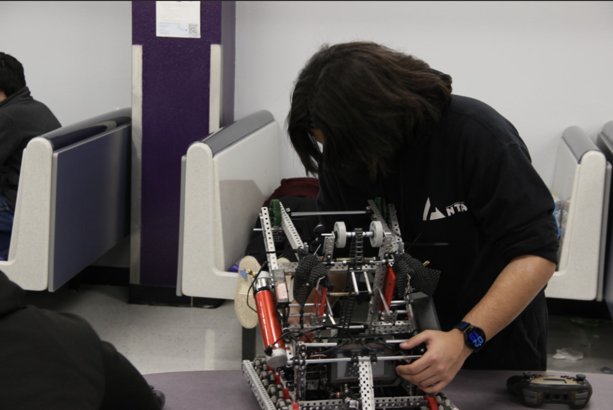 Hanks students adjust parts of their robot's intake after losing their first match.